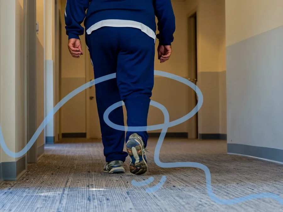 Older adult walking in a senior living corridor